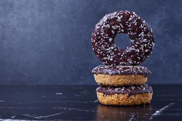 Chocolade donuts op blauwe ondergrond.