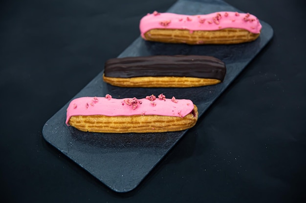 Gratis foto chocolade en bessen eclairs close-up op een zwarte achtergrond