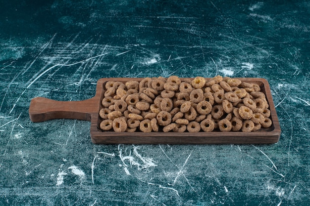 Chocolade maïs ringen op een bord, op de blauwe achtergrond. Hoge kwaliteit foto
