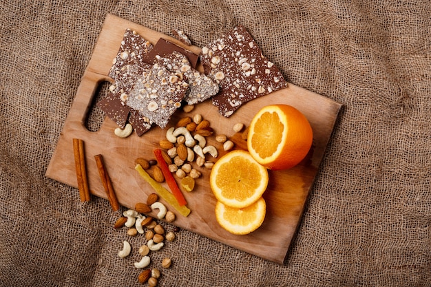 Chocolade oranje kaneel en noten op houten bureau.