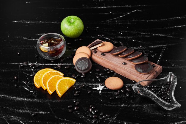 Chocolade spons koekjes op een houten bord met kruidenthee.