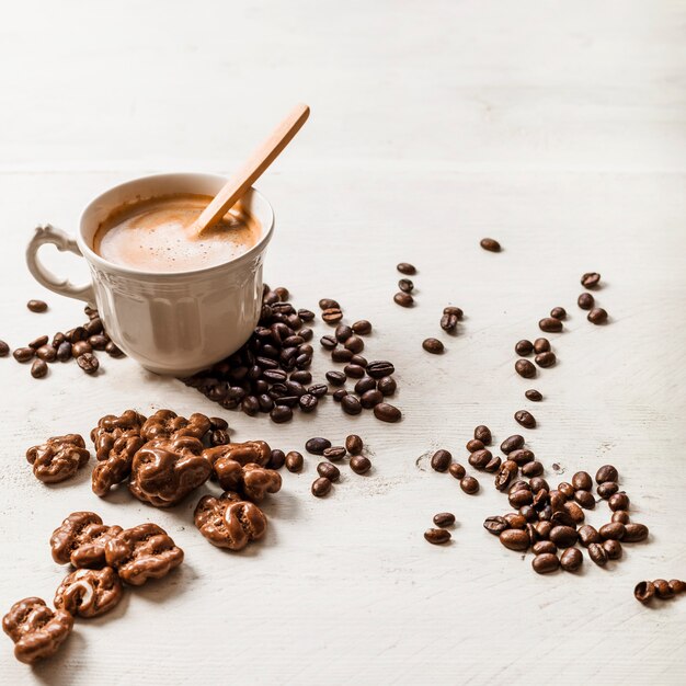 Chocolade walnoot; gebrande koffiebonen en koffiekopje op houten achtergrond