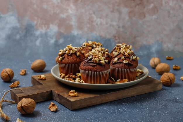 Chocolade-walnootmuffins met koffiekop met walnoten op donkere oppervlakte