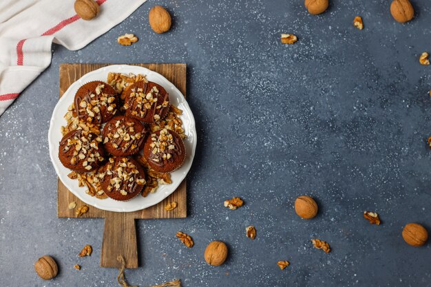 Chocolade-walnootmuffins met koffiekop met walnoten op donkere oppervlakte