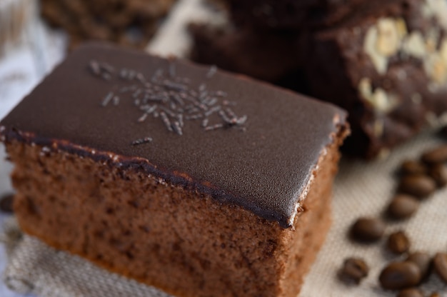 Chocoladecake op een witte plaat met koffiebonen op een houten lijst