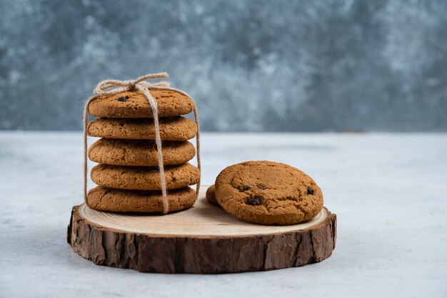 Chocoladekoekjes in touw op een houten bord.