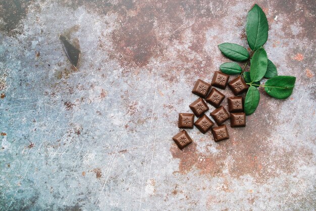 Chocoladestukjes met bladeren op grunge rustieke achtergrond