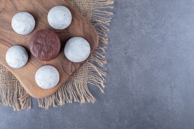 Chocoladetaart knalt en koekje aan boord op de handdoek op marmeren tafel.