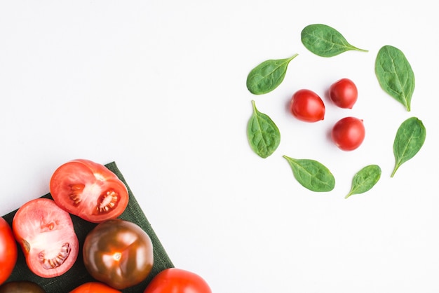 Gratis foto cirkel van spinazie in de buurt van tomaten