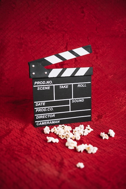 Clapperboard en popcorn op fluwelen zitvlak