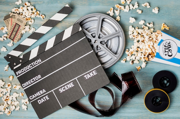 clapperboard; popcorn; filmstrip en bioscoopkaartjes op houten bureau
