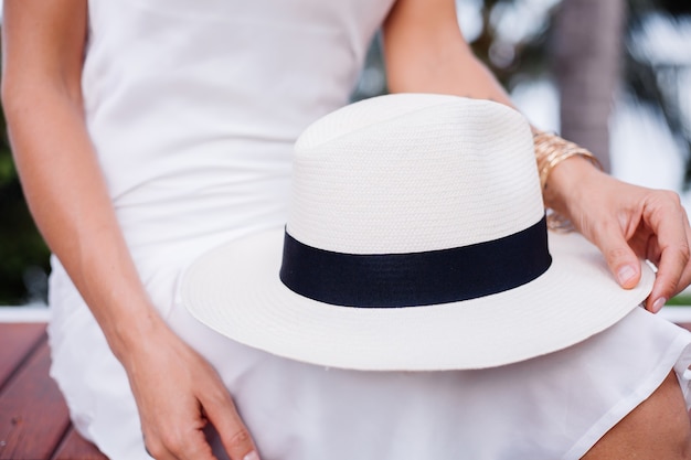 Close shot vrouw in zijden passende jurk met klassieke witte hoed