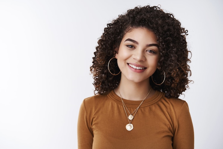 Gratis Foto close-up aangenaam krullend donker haar vrouwelijke klantenondersteuningsmanager glimlachend in grote lijnen klaar helpen interesse tonen geluk grijnzende witte tanden opgetogen hebben een positief gesprek, studio achtergrond