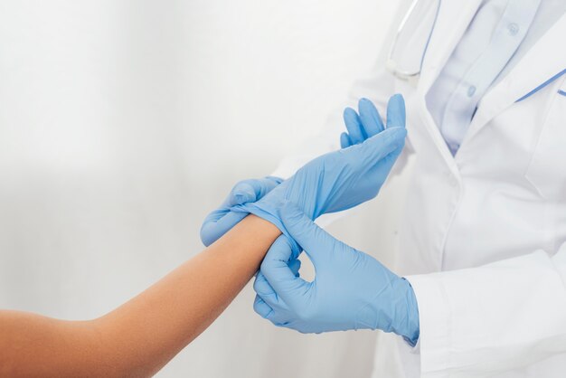 Close-up arts handschoen bij de hand zetten