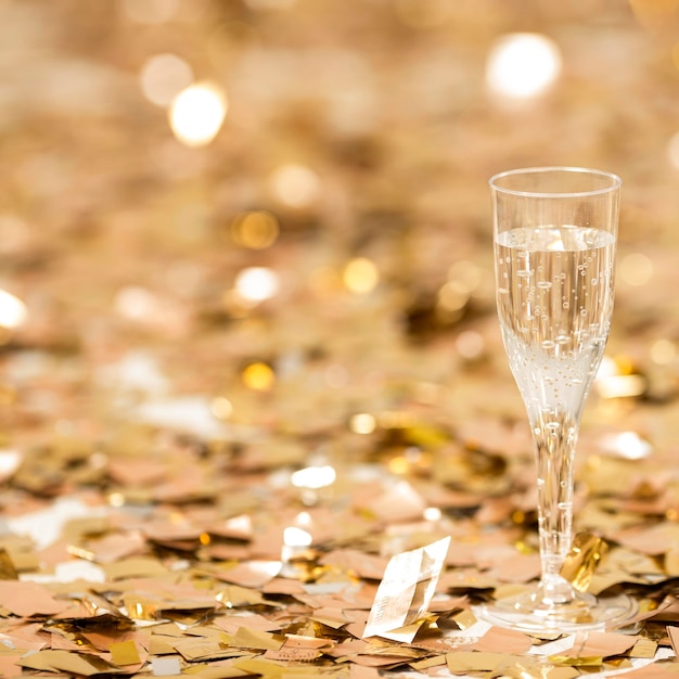 Gratis foto close-up beeld van champagne glas met confetti