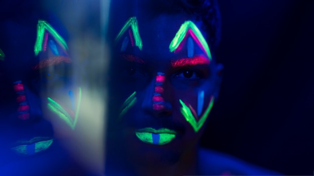 Close-up beeld van man met kleurrijke fluorescerende make-up