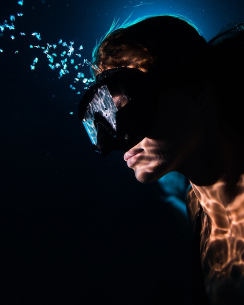 Gratis foto close-up beeld van mooie vrouw in zwembad water zwemmen masker dragen