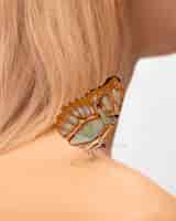 Gratis foto close-up beeld van prachtige vlinder op schouder