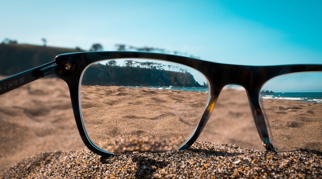 Close-up beeld van strand gezien vanuit de lenzen van zwarte bril