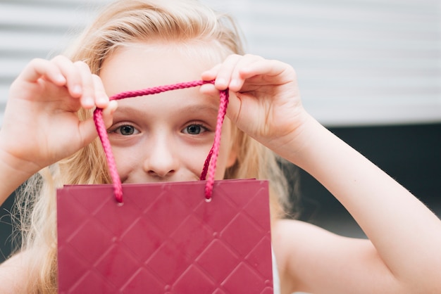 Gratis foto close-up blond meisje met cadeauzakje