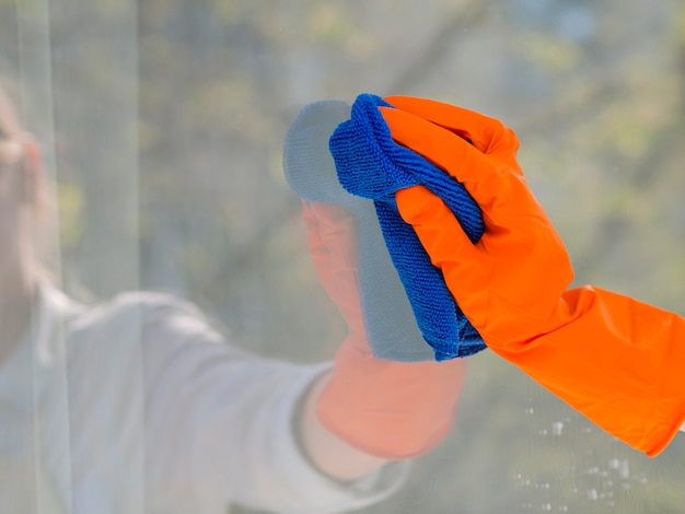 Gratis foto close-up die het venster met doek schoonmaken