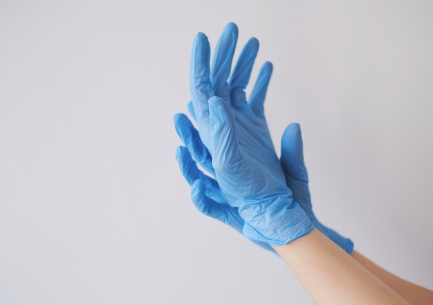 Gratis foto close-up die van de handen van een persoon is ontsproten die blauwe handschoenen dragen