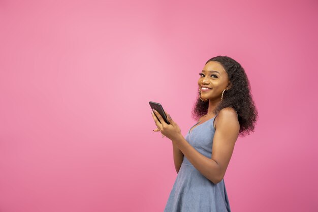 Close-up die van een mooie vrouw in een opwindende bui is ontsproten die haar telefoon vasthoudt