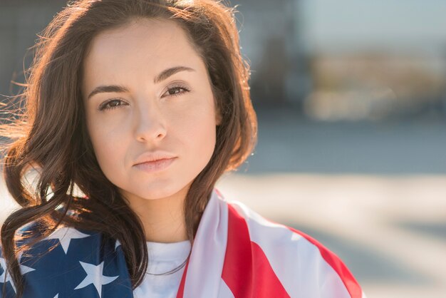 Close-up donkerbruine vrouw die de grote vlag van de VS houdt