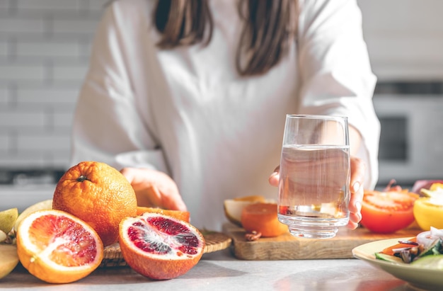 Gratis foto close-up een glas water in vrouwelijke handen in de keuken