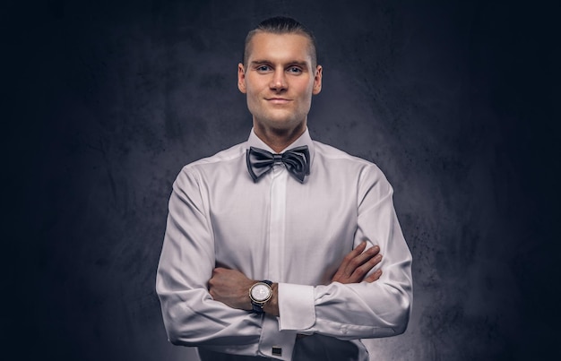 Gratis foto close-up, een portret van een casual knappe man in een wit overhemd tegen een donkere achtergrond.