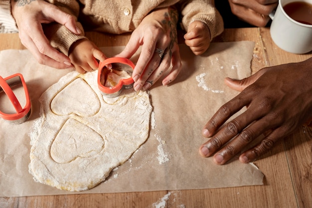 Close-up familie en kind koekjes maken