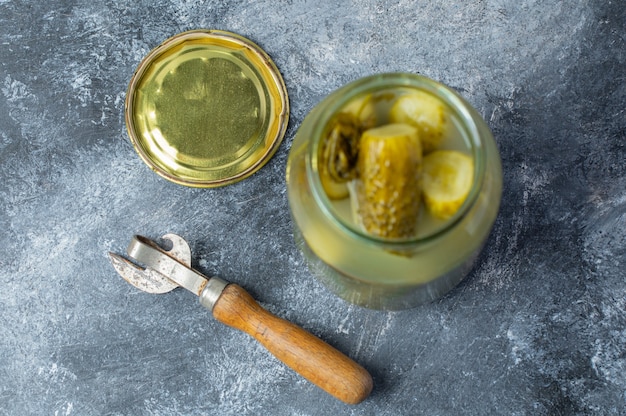 Gratis foto close-up foto van geopende pot vol met ingemaakte komkommer op grijze tafel.