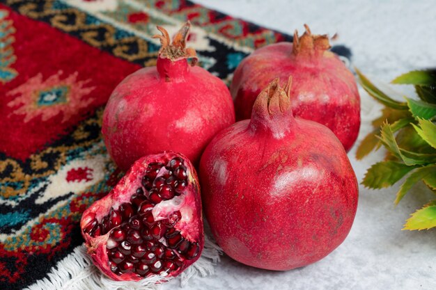 Close-up foto van gesneden of hele granaatappels over oud tapijt.