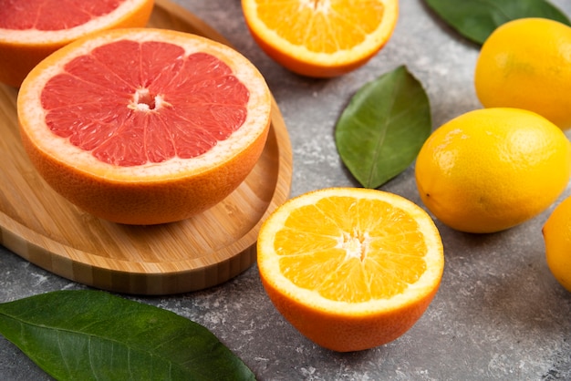 Close-up foto van sinaasappel en grapefruit plakjes op grijze ondergrond.