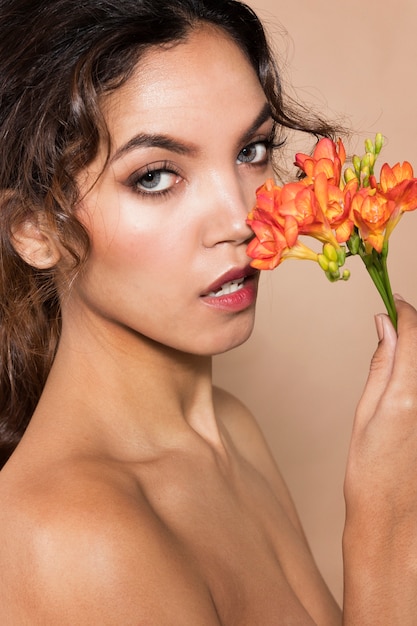 Gratis foto close-up geschotene vrouw die vibran mooie bloemen houden