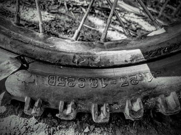 Gratis foto close-up grijze schaal die van een motorfietsband is ontsproten op de modderige grond