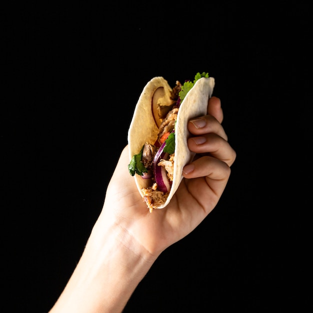 Gratis foto close-up hand met taco met vlees