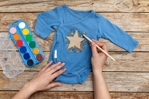 Gratis foto close-up hand tekenen op babykleding