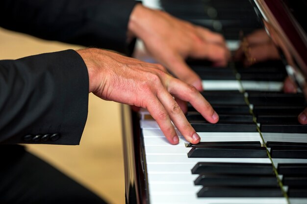 Close-up handen met akkoorden op klassieke piano