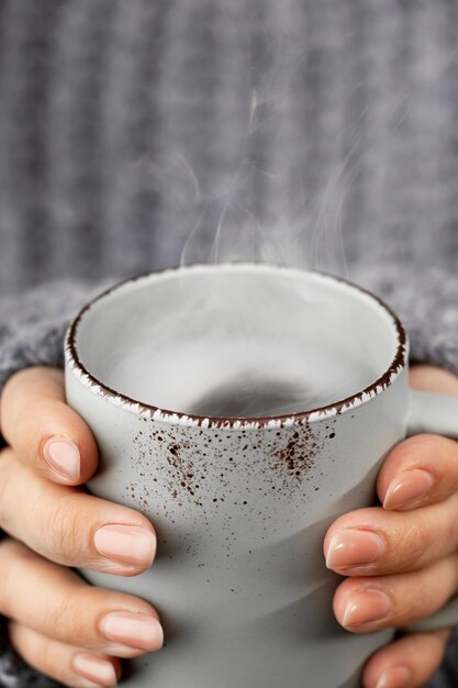 Close-up handen met warme drank