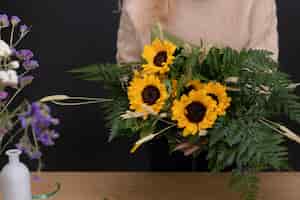 Gratis foto close-up handen met zonnebloemen