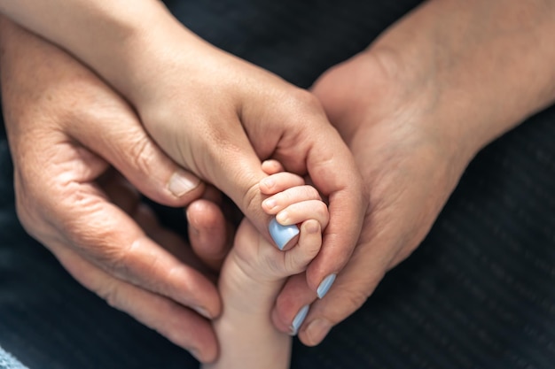 Gratis foto close-up handen van een baby moeder en grootmoeder