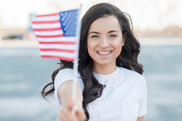 Close-up het donkerbruine de vlag van de VS van de vrouwenholding glimlachen