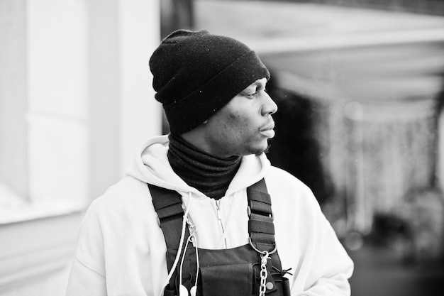 Close-up hoofd van stijlvolle stedelijke stijl Afro-Amerikaanse man in roze hoodie en zwarte hoed geposeerd