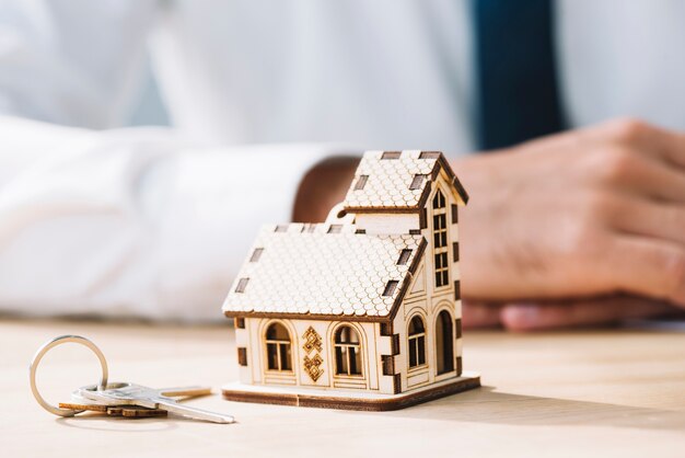 Close-up huis en sleutels in de buurt van onroerende goederenagent