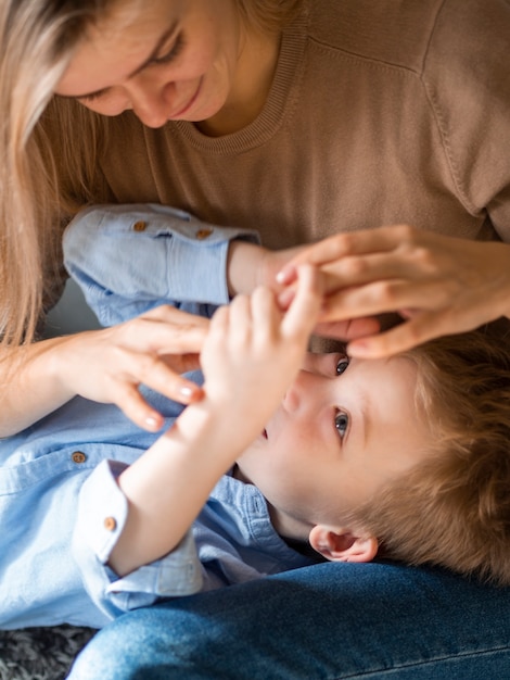 Close-up jonge jongen speelt met zijn moeder