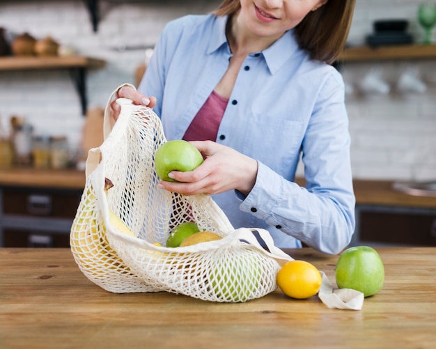 Close-up jonge vrouw met tas met vers fruit