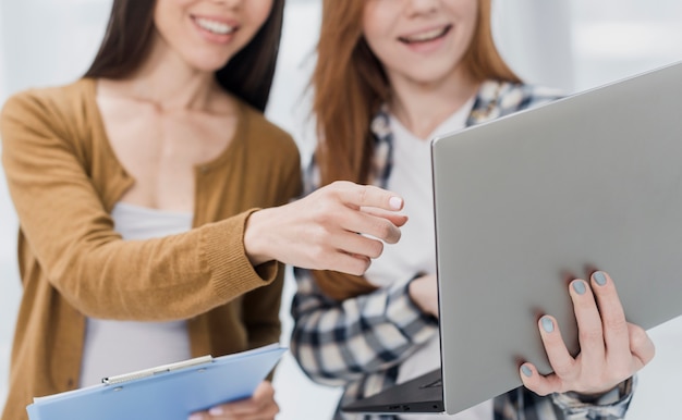 Close-up jonge vrouwen die op laptop doorbladeren