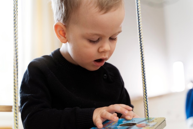 Gratis foto close-up kind kijken naar kleurrijk boek