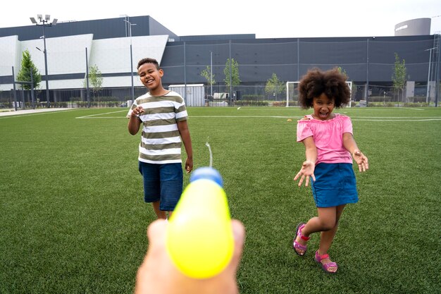 Close-up kinderen spelen met waterpistool